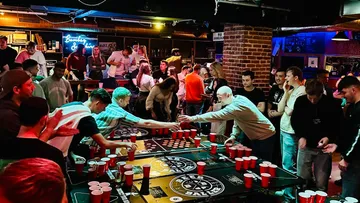 People playing beer pong in a bar.
