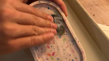 Hand polishing colorful terrazzo tray.
