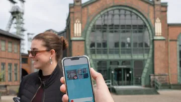 Smartphone-Foto von Frau und historischem Gebäude.