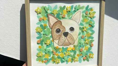 Gerahmtes Hundegemälde von Blumen umgeben.
