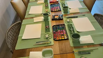 Art supplies set on a wooden table.