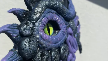 Sculpted dragon eye detail close-up outdoors.