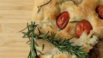 Focaccia mit Tomaten und Rosmarin auf Holz