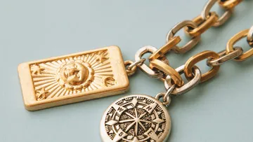 Goldene Kette mit Sonnen- und Kompass-Anhängern.