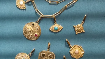 Goldschmuck auf blauer Oberfläche angeordnet.