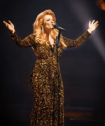 Sängerin auf der Bühne im glitzernden Kleid.