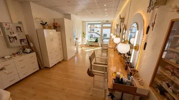 Moderner Salon mit Stühlen und Spiegeln.