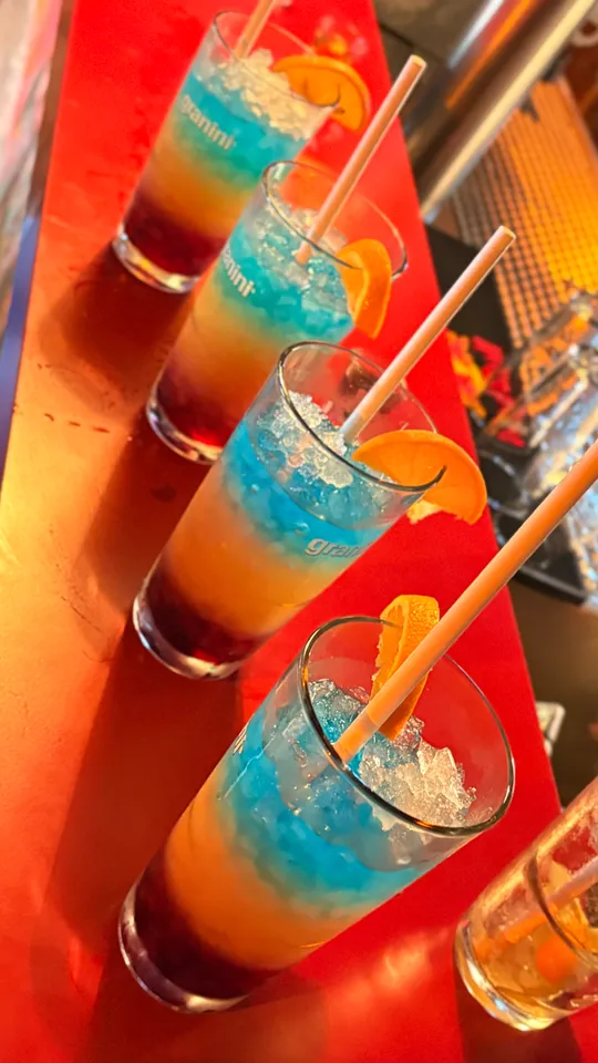 Bunte Cocktails mit Orangenscheiben auf der Bar.