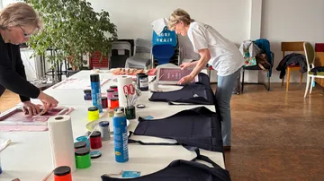People printing shirts in an art studio.