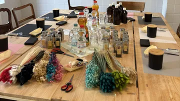 Workshop table with bottles and dried flowers.