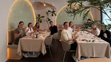 Personen essen, lächeln in einem dekorierten Restaurant.