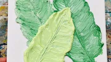 Drei strukturierte grüne Blätter auf weißem Canvas.