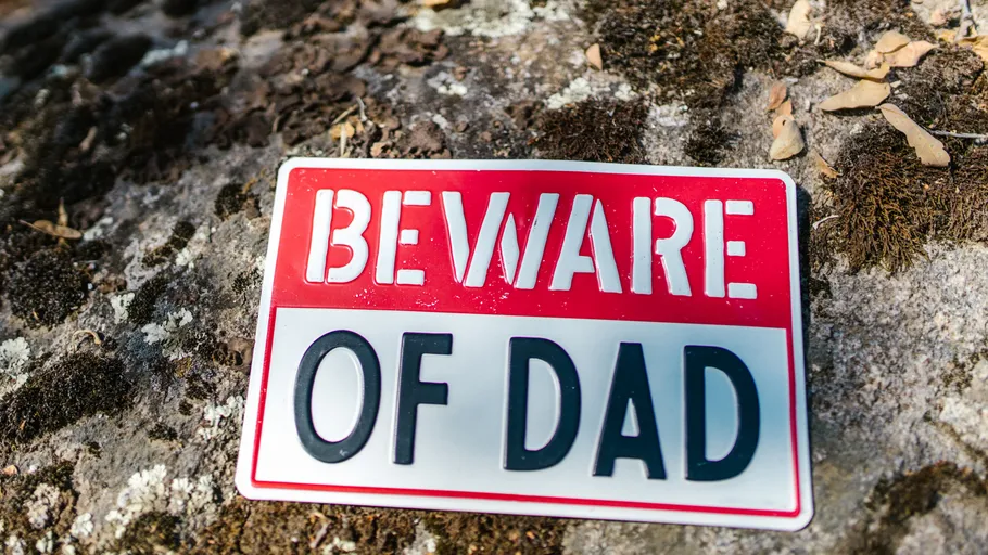 Sign on ground reads "Beware of Dad".