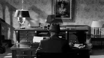 Man sitting at desk, typing in office.