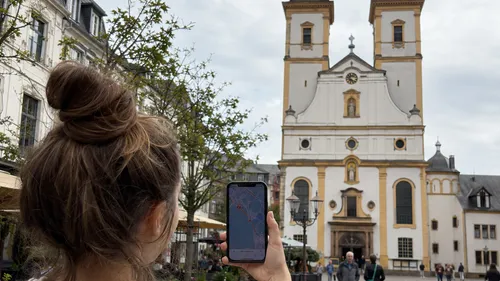 Person hält Handy vor Kirche