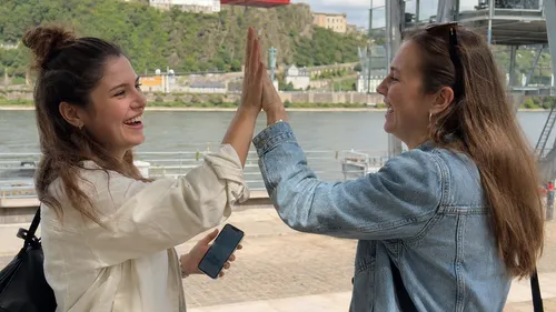 Zwei Frauen geben sich High-Five am Fluss.