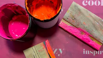 Two open paint cans, board nearby.