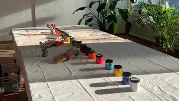 Paint jars on a table in a studio.