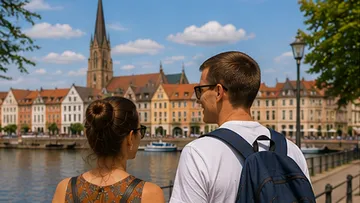 Couple enjoys scenic waterfront, historic buildings.