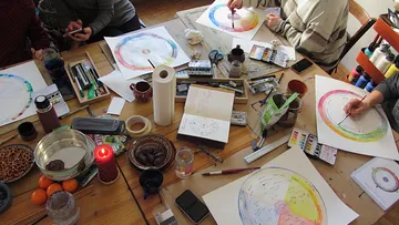 Personen malen Mandalas, Holztisch-Anordnung.