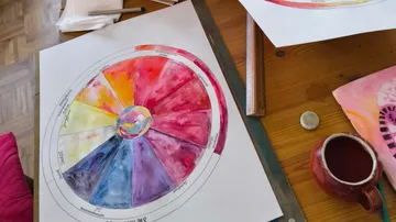 Color wheel painted on paper on desk.