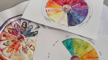 Three colorful painted color wheels on a table.
