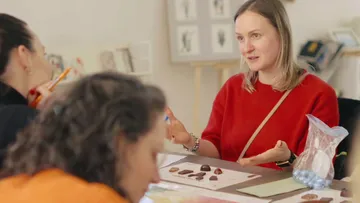 Person erklärt Pralinen an einem Tisch.