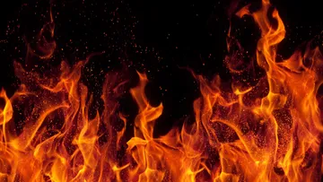 Helle Flammen steigen vor dunklem Hintergrund.