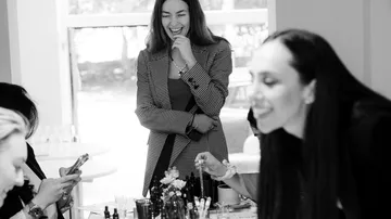 Frauen lachen am Tisch mit Make-up.