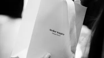 Weißer Beutel mit Atelier Inspire Schriftzug.