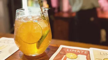 Ein Glas Eistee auf Holztisch.