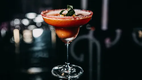 Cocktail mit Garnitur auf dunkler Theke.