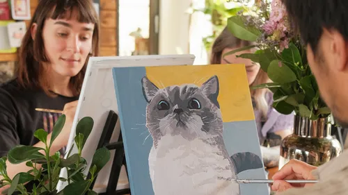 Group painting cat portrait in art studio.