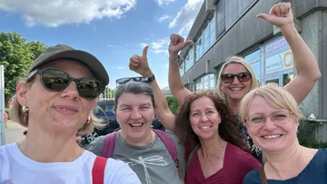 Gruppe Frauen lächeln draußen, Daumen hoch.