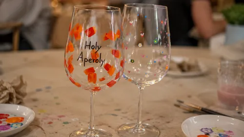 Two painted glasses on a craft table.