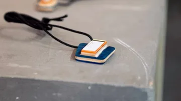 Anhänger an einer Schnur auf einem Tisch.