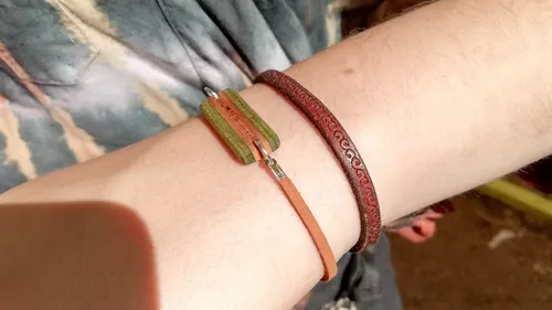 Zwei Armbänder an einem Handgelenk draußen.