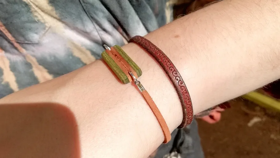 Zwei Armbänder an einem Handgelenk draußen.