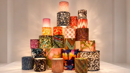 Colorful lampshades stacked in pyramid shape indoors.