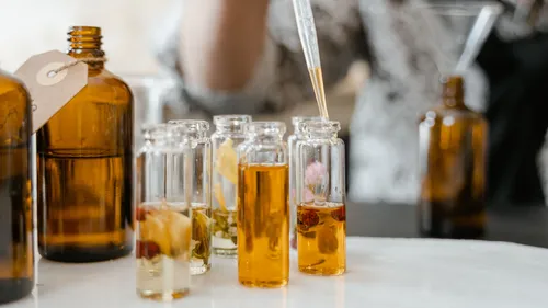 Glass jars with infused oils on table.