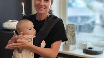 Frau hält Baby in Kunstgalerie.