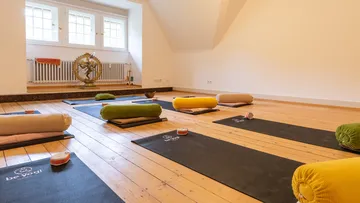 Yogamatten im Studio mit Kissen arrangiert.