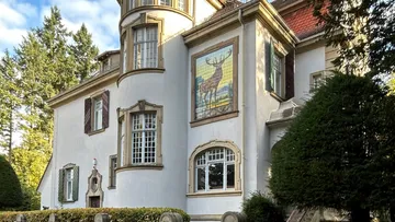 Großes Haus mit Hirschbild außen.