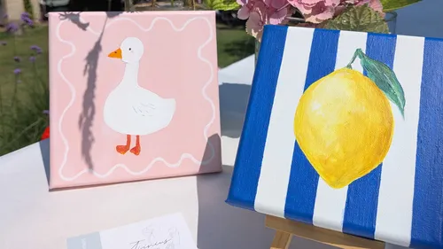 Canvas with duck and lemon paintings outdoors.