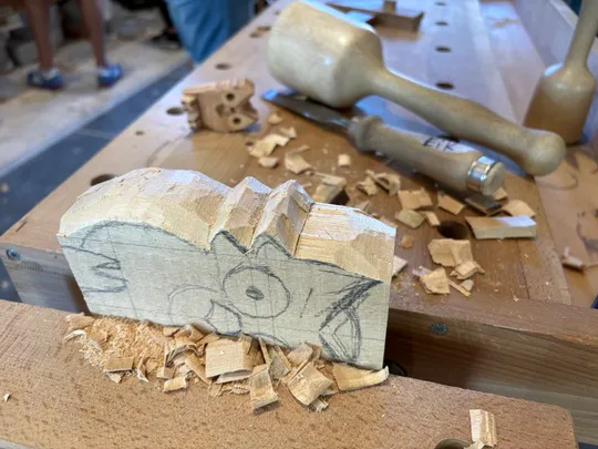 Holzblock mit Schnitzumrissen, Werkstattumgebung.