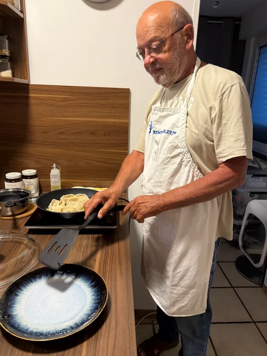 Man cooking dumplings on an induction hob.
