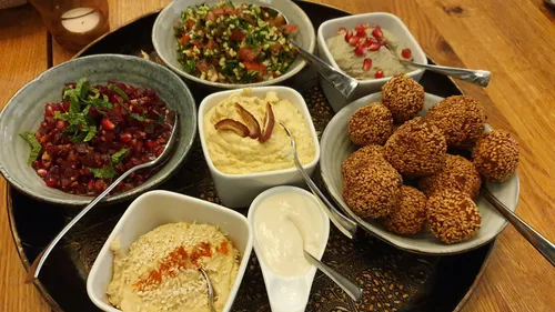 Middle Eastern mezze platter on wooden table.