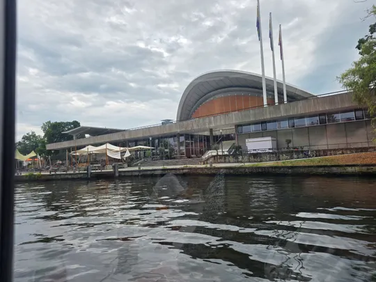 Modernes Gebäude mit gewölbtem Dach am Wasser.