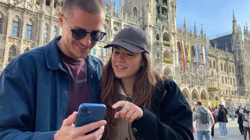 Two people looking at a smartphone outdoors.