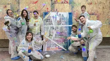 Gruppe malt bunte Leinwand im Studio.